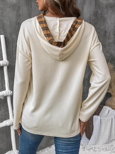 Detail view of the waffle knit texture and plaid lined hood on a casual women top