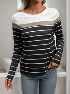 Close-up of three-color patchwork long sleeve T-shirt with striped bottom and round neck