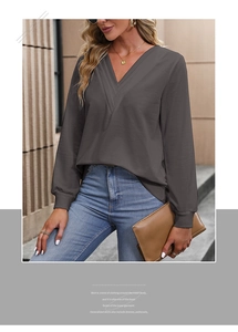 Detailed view of deep grey V-neck long sleeve top with textured knit and ribbed cuffs
