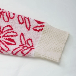 Detail of pink and red jacquard knit sleeve with ribbed cuff on Fair Isle sweater