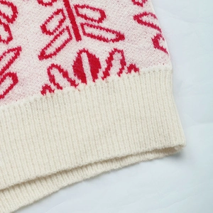 Detail of pink and white jacquard knit sweater with soft texture and ribbed hem