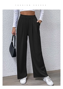 Detail view of black high waisted wide leg trousers featuring elegant front pleats and pockets