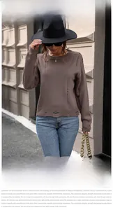 Detail shot of distressed round neck knit sweater with worn-out cuffs and collar design