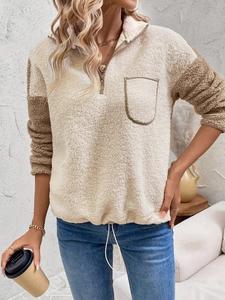 Detail of sherpa pullover featuring contrast sleeves, 1/4 zipper, and adjustable hem drawcord