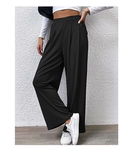 Detail of high-waisted black wide-leg trousers with ribbed texture and pleated waist design