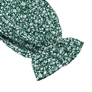 Détail des poignets élastiques à volants sur manches longues avec imprimé floral vert foncé