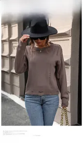 Detail of distressed ribbed cuffs and hem on a vintage brown crewneck knit sweater