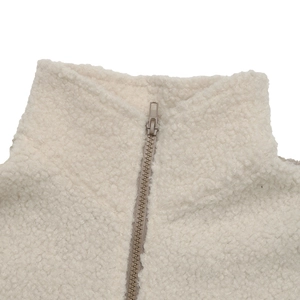 Detail of cream sherpa fleece texture and khaki resin zipper on stand collar jacket