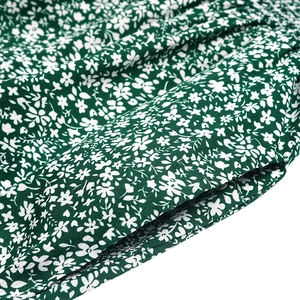 Détail de combinaison fleurie avec poche latérale et coutures fines sur tissu vert