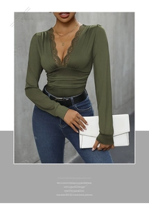 Close-up of deep green long sleeve bodysuit with delicate lace V-neckline and waist folds