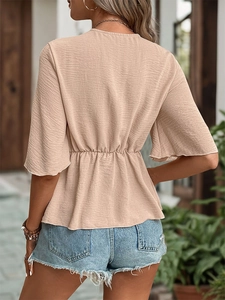 Back view of apricot textured short sleeve top with bell sleeves and peplum waist