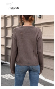 Detailed view of distressed brown knit sweater with ripped holes and ragged texture edges