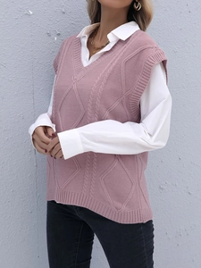 Détail d'un pull sans manches rose à col en V superposé sur une chemise blanche chic