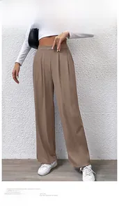Detail view of brown wide-leg trousers featuring a high waist and pleated texture fabric