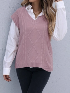 Détail du gilet en tricot rose avec col en V, motifs torsadés et losanges texturés