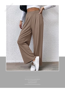 Detail of high-waist elastic waistband and ribbed texture on brown wide-leg trousers