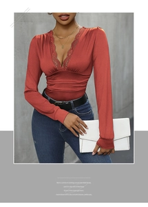 Detailed view of deep V-neck lace trim and pleated satin texture on red long sleeve bodysuit