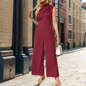 Elegant burgundy sleeveless wide-leg jumpsuit with draped neckline on a scenic city street