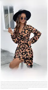 Detail of leopard print wrap dress showing V-neck, waist tie, and soft fabric texture