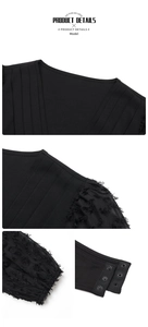 Detail view of black V-neck bodysuit showing textured mesh sleeves and snap button closure