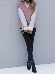 Vue complète d'un pull sans manches rose sur chemise blanche avec un jean noir pour femme