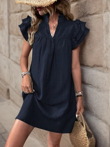 Detail of dark textured fabric dress with V-neckline and layered ruffle cap sleeves