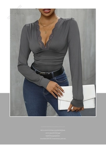 Detailed close-up of deep V-neckline with delicate lace trim and ruching on grey bodysuit