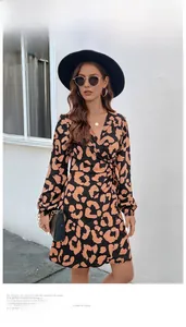 Detail of leopard print wrap dress featuring deep V-neckline and waist tie design