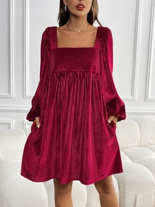Detail of burgundy velvet dress fabric featuring vertical pleated texture and square neckline