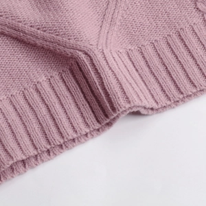 Détail du gilet en maille torsadée mauve avec poignets côtelés et tissage épais texturé