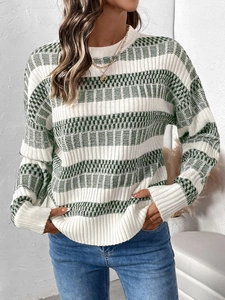 Detail of green striped knit sweater showing textured weave and white ribbed cuffs