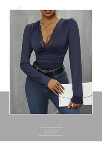 Detail of elegant lace patchwork on V-neckline of a deep blue slim fit long sleeve bodysuit