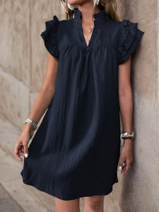 Detail of navy blue sleeveless dress featuring ruffled shoulders and textured seersucker fabric