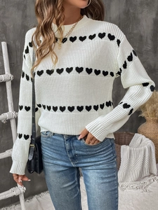 Detailed close-up of heart pattern knit sweater with ribbed cuffs and textured stitch
