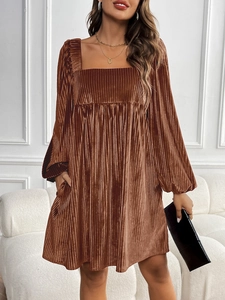 Détail d'une robe en velours marron avec encolure carrée et poches latérales pratiques