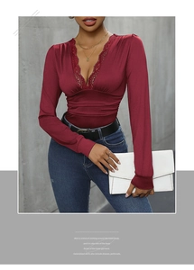 Detail of burgundy long sleeve bodysuit with lace V-neckline and ruching textures