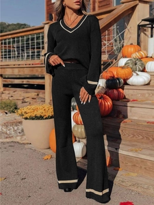 Detail of V-neck knit set featuring contrast trim on sleeves and high-waisted wide trousers