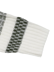 Detailed close-up of ribbed cuffs on a white and olive green striped knitted sweater