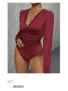 Detailed close-up of wine red bodysuit with deep V-neck lace patchwork and satin texture