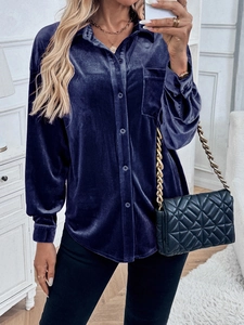 Detail of soft dark blue velvet texture on a long-sleeve shirt with lapel and front pocket
