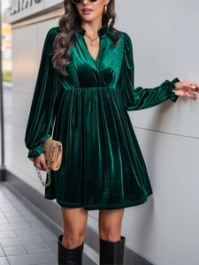 Détail de la robe de soirée en velours vert foncé avec décolleté en V et taille haute plissée