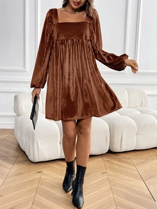 Détail de la robe en velours marron avec texture plissée fine et encolure carrée chic