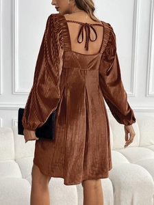 Détail de la robe en velours avec encolure carrée, dos nu et nœud de serrage délicat