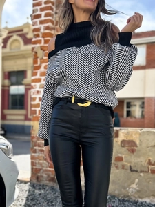 Detail von Chevron-Strickpullover mit Cut-Outs und goldener Mond-Gürtelschnalle