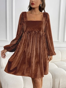 Détail de la robe en velours marron café avec plis verticaux, col carré et manches lanternes