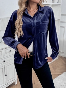Detail view of the deep blue velvet long sleeve shirt with shiny texture and front pockets