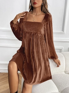 Détail de robe courte en velours à col carré montrant la texture plissée et satinée