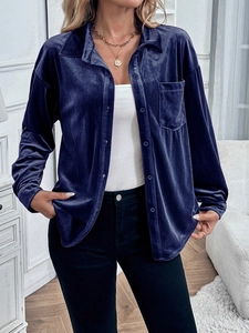 Detail of the deep blue velvet shirt showing premium texture and metallic buttons