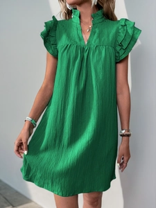 Detail of green V-neck dress showing textured pleated fabric and layered ruffle sleeves