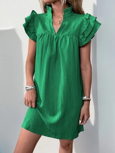 Detail of green summer dress featuring layered ruffle sleeves and textured crinkle fabric